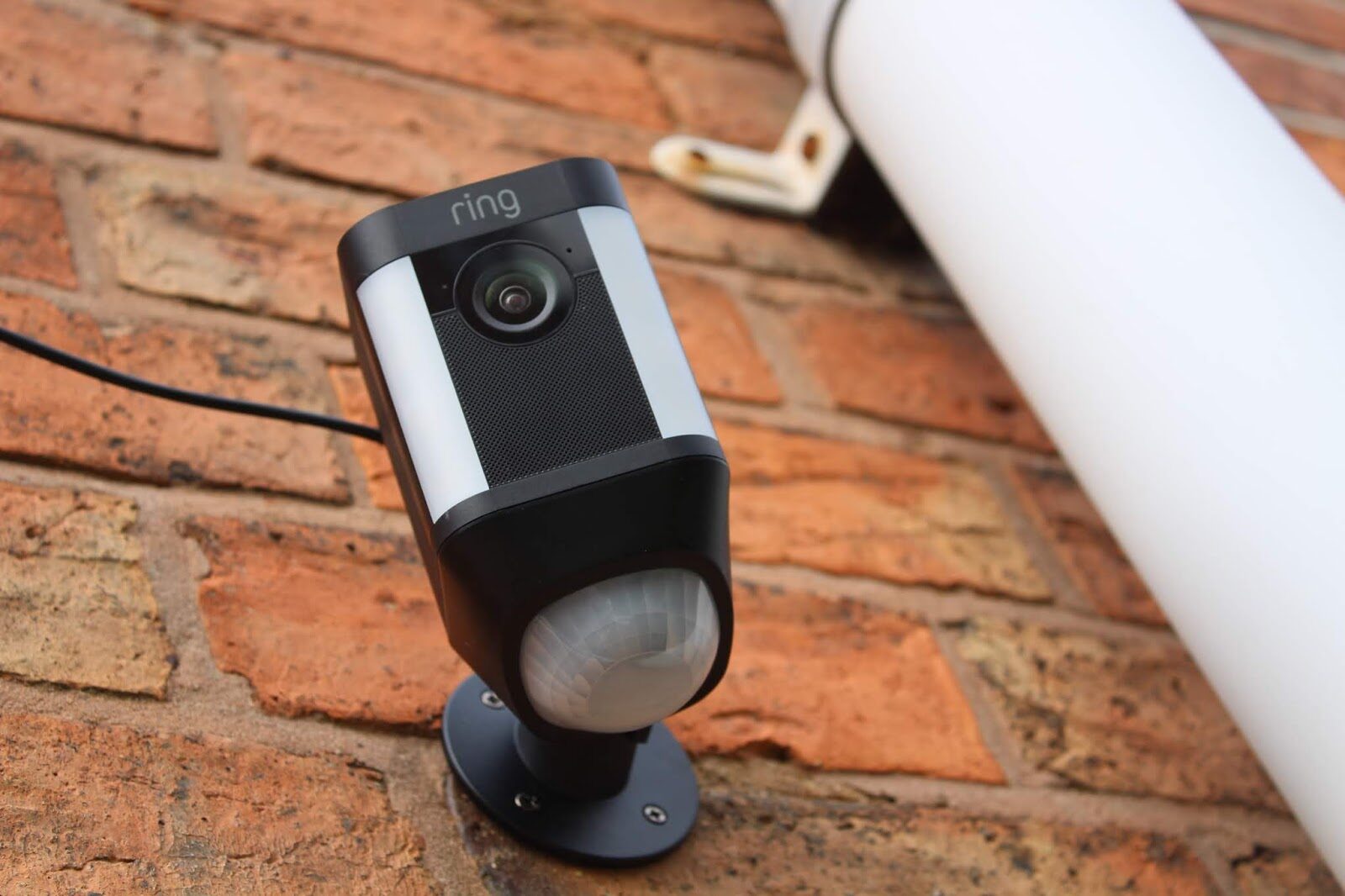 Compact security camera fitted beside the front door on a brick house exterior