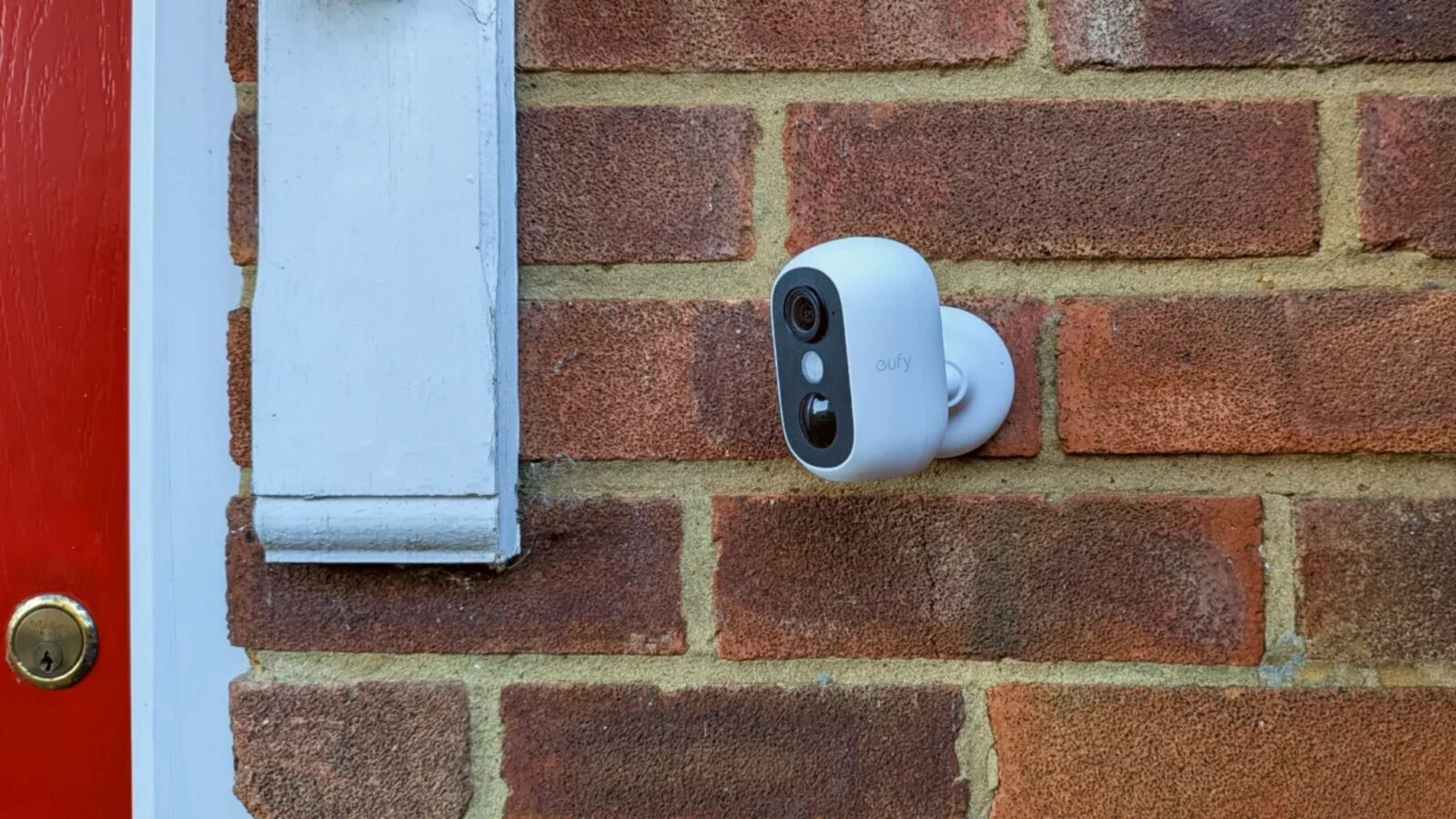 Dual-lens security camera installed under the eaves on a brick house exterior